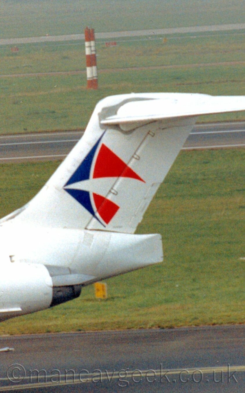 Closeup of the tail of a white T-tailed jet airliner beraing a square red, white, and blue logo vaguely resembling a couple of triangular sails.