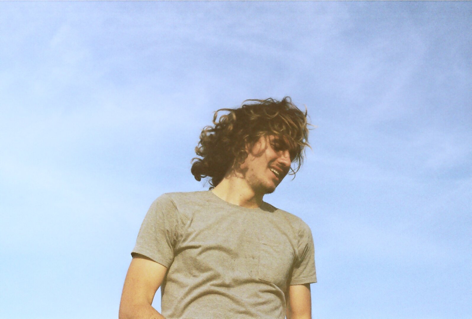 A person, their face obscured by hair as they toss their head